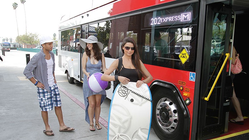 photo of people in front of an rta bus with beach gear